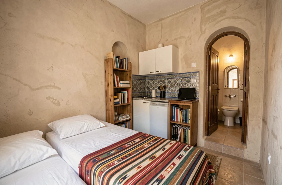 Intérieur d'un studio meublé à louer par mois à Essaouira, idéal pour étudiant ou stagiaire, avec carrelage zellige et couverture berbère